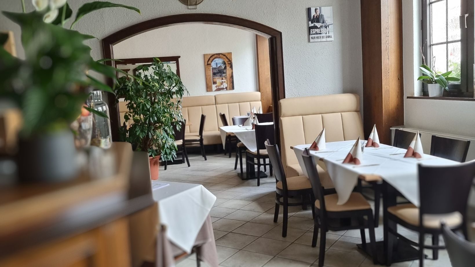 Der Gastraum von Bei Anna mit eingedeckten Tischen und Sitzbänken